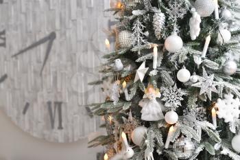 Silver decoration in the form of stars, balls and garlands hanging on a Christmas tree with a snow effect