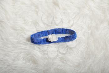 Cute children's knitted bandage strip of blue on a white carpet background