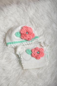 Cute baby taken set of panties and a white hat for newborns on a white carpet