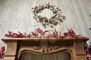 A beautiful knitted wreath of cotton plant hanging over fireplaces decorated with Rowan branches in the Christmas holidays