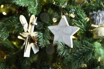 Beautiful wooden star and little ski decoration hanging on a Christmas tree