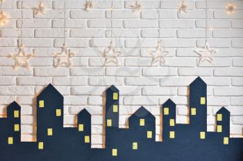 Decorations of the children's room for the New Year or Christmas, the silhouette of the city on a background of a white brick wall