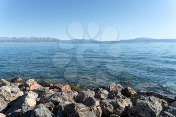 The calm surface of the lake and rocks. Shot in Sayram Lake, Xinjiang, China.