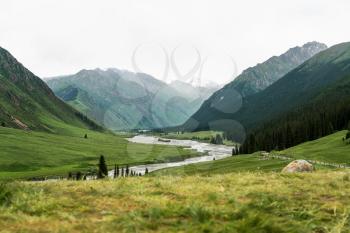 River and mountains with white clouds. Shot in Xinjiang, China.