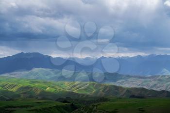 Grassland and mountains in a cloudy day. Shot in Xinjiang, China.