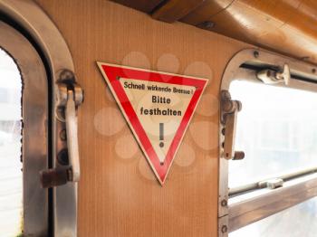 Schnell wirkende Bremse, Bitte festhalten (meaning Quick-acting brake, please hold tight) sign on vintage German tram