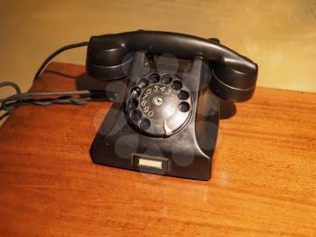 vintage black analog rotary dial telephone on a desk