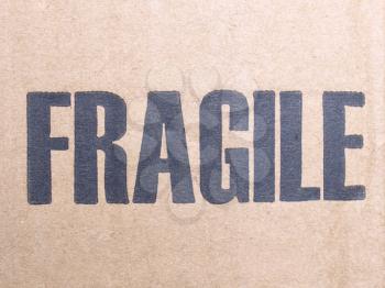 Fragile warning sign label tag on a cardboard box packet parcel for mail post shipping