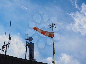 windsock and aerials over blue sky with clouds