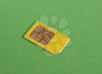 telephone sim card over green background with copy space