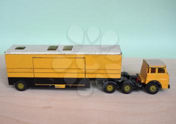 Vintage scale model yellow lorry with selective focus. Articulated vehicle with tractor and trailer.