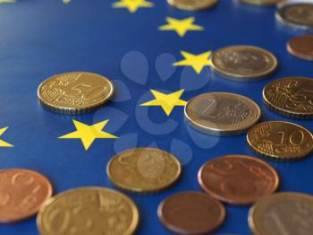 Euro coins (EUR), currency of European Union over flag of Europe