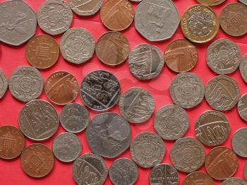 Pound coins money (GBP), currency of United Kingdom, over red background