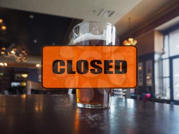 Empty pub, closed sign, pint of ale