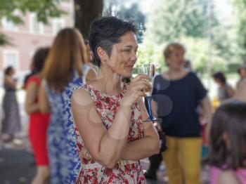Gorgeous elegant woman drinking champagne at party. Selective focus on model, with blurred bokeh background.