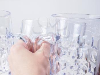 A hand holding many empty beer glasses