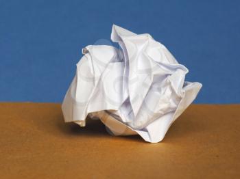 white crumpled paper sheet over brown and blue paper background with copy space