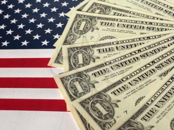 One Dollar banknotes (USD) currency money over the flag of the United States