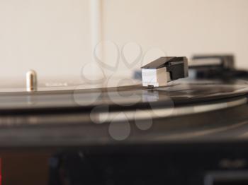 Vinyl record spinning on a turntable, focus on needle