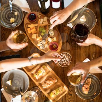 People drinking wine, eating snacks at the restaurant, top view