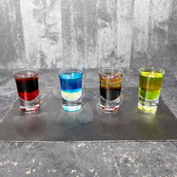 Colorful alcohol vodka cocktails on a gray background