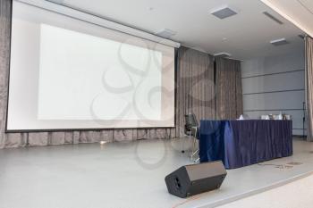 Empty event hall with table and projector