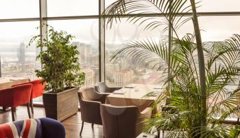 Beautiful restaurant interior with plants, city view