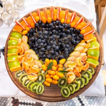 A lot of fruits on the wooden plate