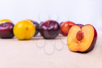 Red, yellow slice plum fruit close up on the white background isolated
