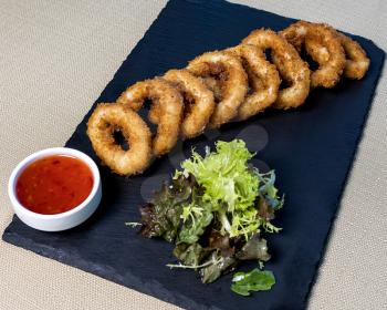 Chicken Ring, nugget, calamari with tomato sauce on the black plate