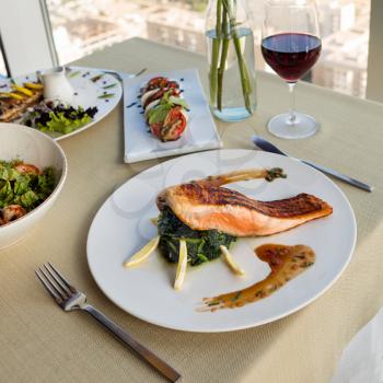 Beautiful salmon meal with lemon and red wine