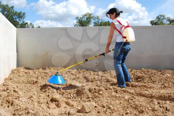 Royalty Free Photo of a Woman Fertilizing the Soil With Sulphate