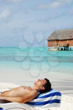 Royalty Free Photo of a Man Sunbathing at a Maldivian Resort