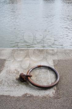 Royalty Free Photo of a Rusty Mooring Ring for Ships on Dock