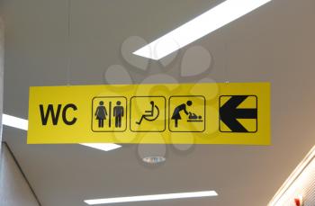 Royalty Free Photo of a Yellow Public Toilet Sign