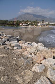 Royalty Free Photo of a Beach With a Stone Pier in Puerto Banus Marbella, Spain