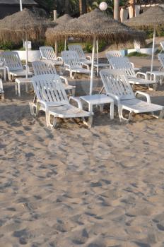 Royalty Free Photo of a Beach With an Umbrella and Chairs