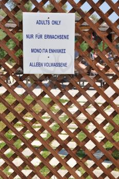 Royalty Free Photo of an Adults Only Sign on a Fence