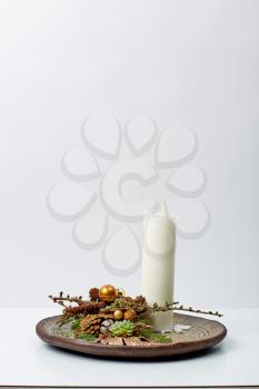 white candle decoration in a wooden bowl on a table