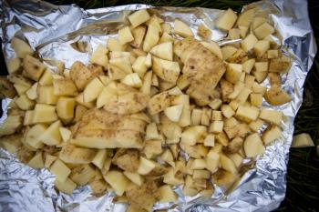 Closeup of raw chopped potatoes in tinfoil