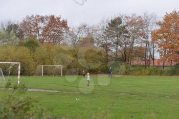 Children playing in a large park with their father