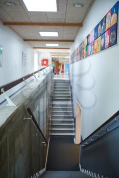 Stairs going down at a school with paintings on the wall