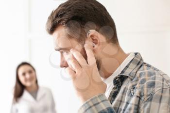 Man with hearing aid in otolaryngologist's office�