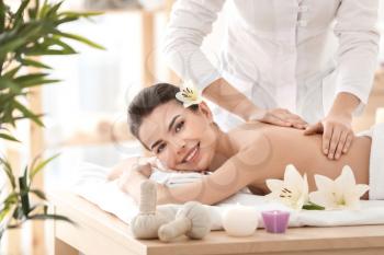 Young woman enjoying massage in spa salon�