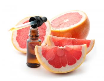 Dropper and bottle of citrus essential oil with sliced fruit on white background�