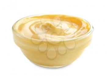 Tasty yellow sauce in bowl on white background�