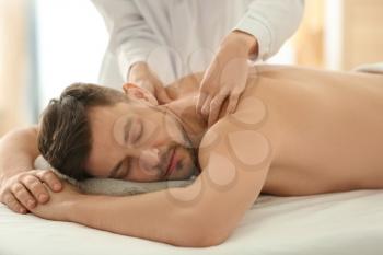 Man having massage in spa salon�