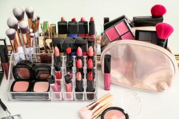 Set of cosmetic products and brushes on table�