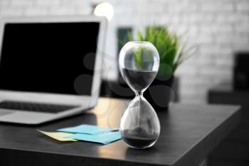 Hourglass on table in office. Time management concept�