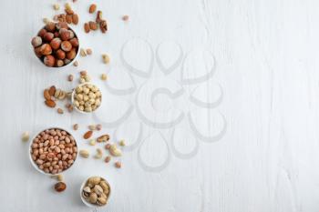 Flat lay composition with different kinds of nuts on light background�